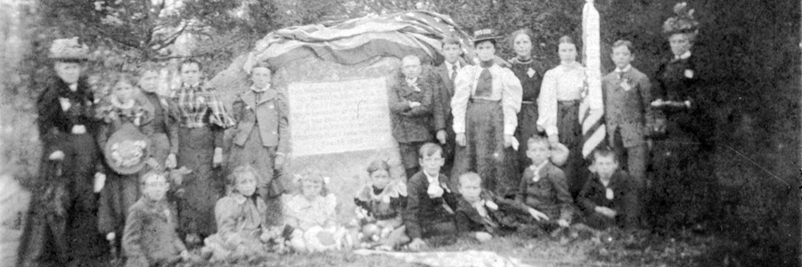 An image of several people standing by a plaque commemorating Fort Decatur